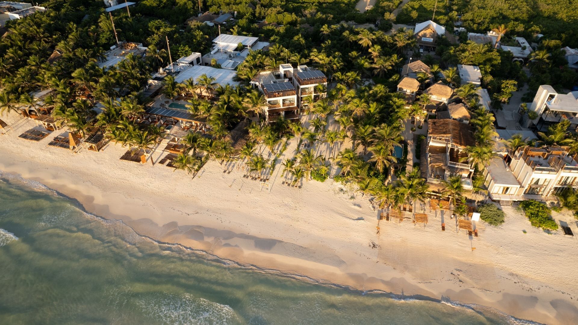 La costa de la zona hotelera desde el aire: arena blanca, mar turquesa y la selva