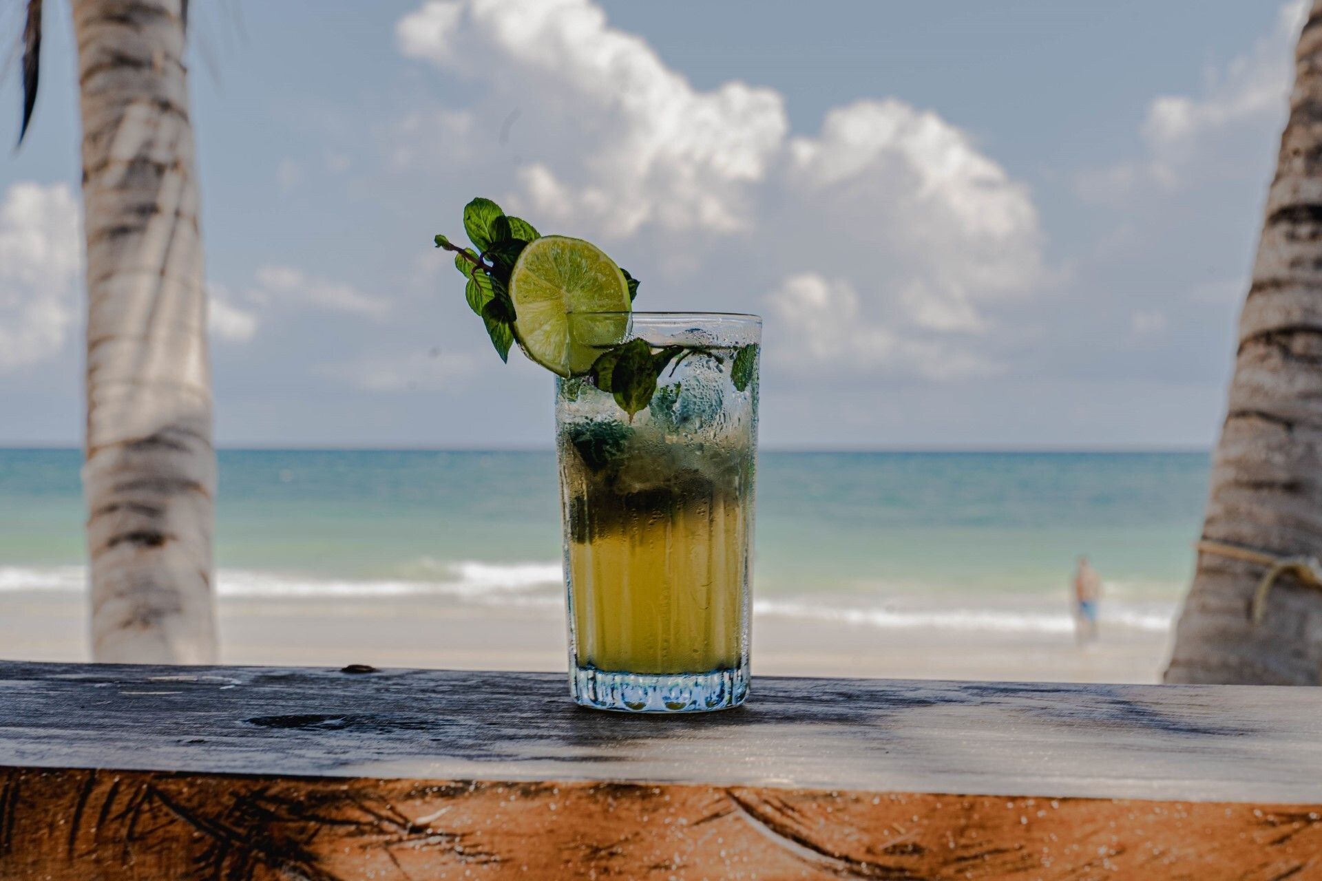 Un mojito sobre la barra de madera frente al mar